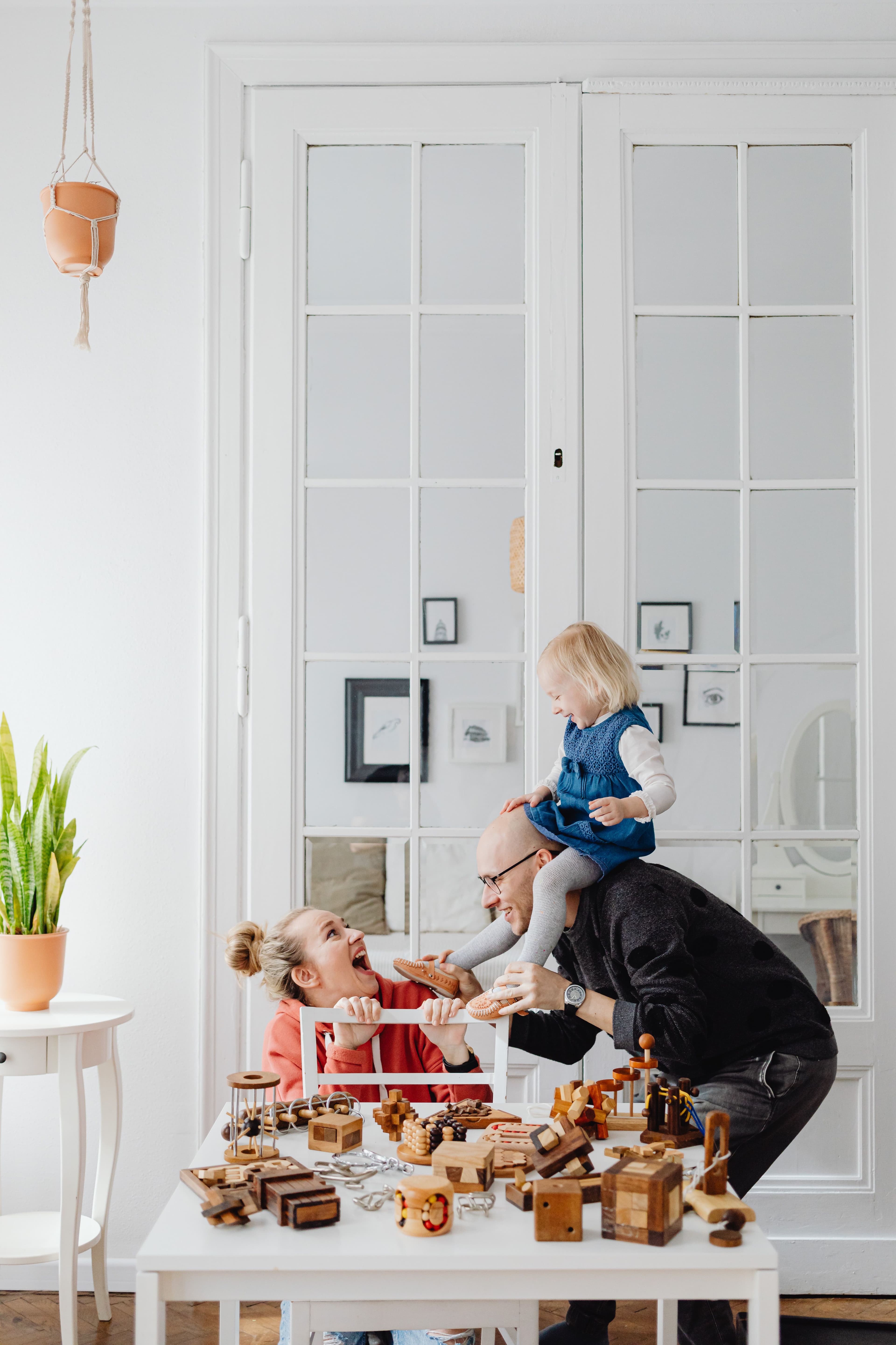 Parent and toddler at a kitchen counter with play materials nearby
