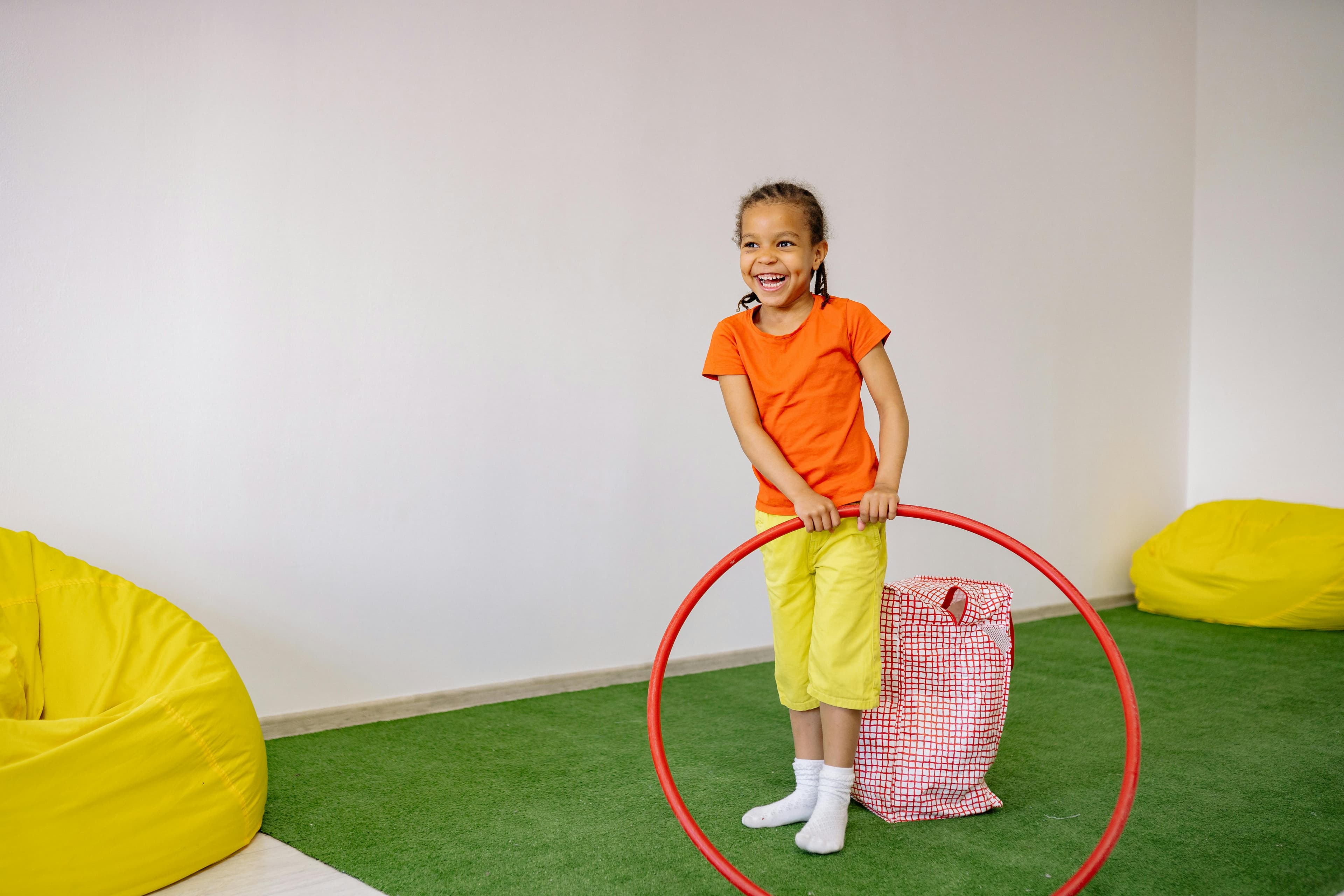 Child balancing along a hula hoop laid flat on the floor