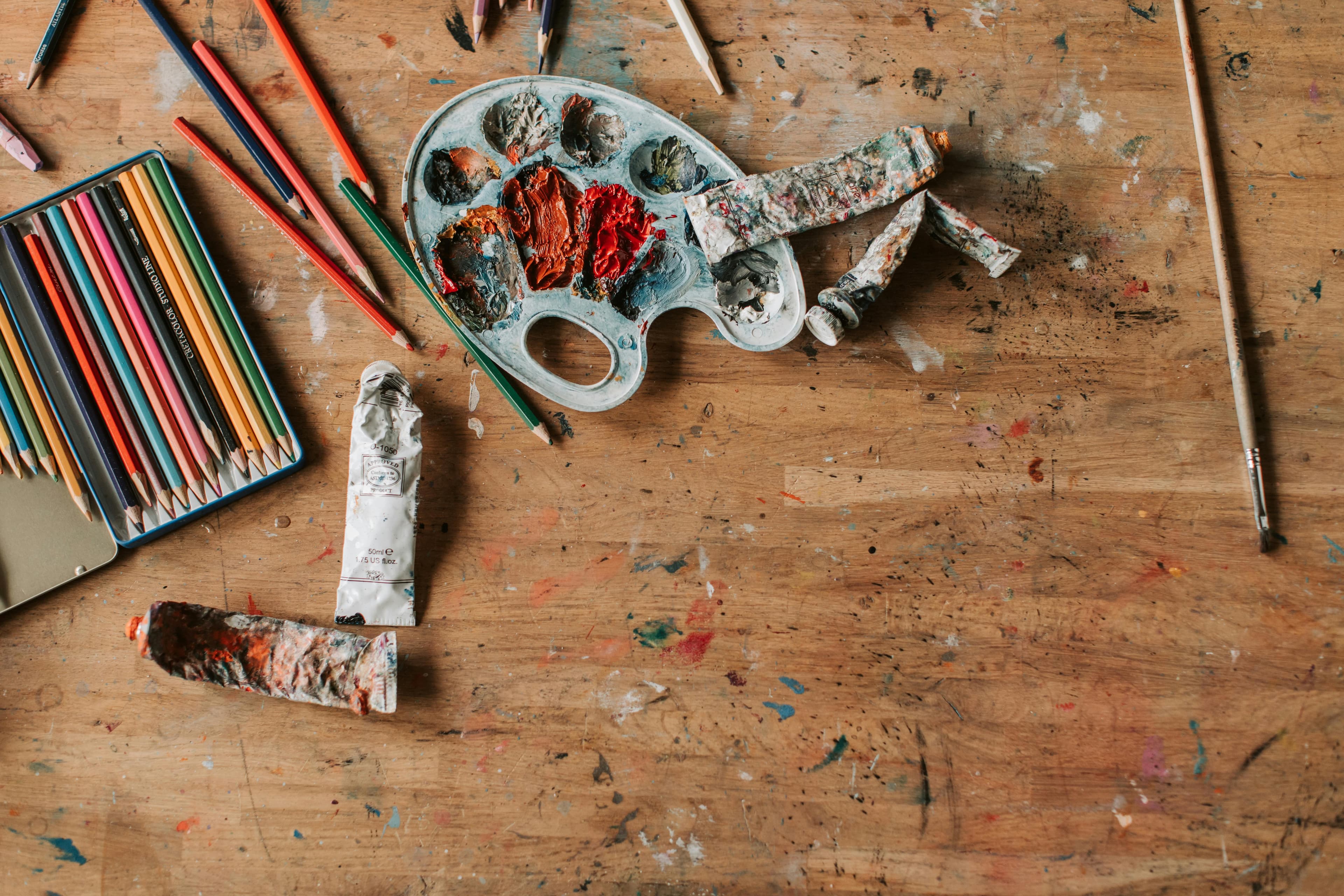Colored pencils and art supplies on a wooden table