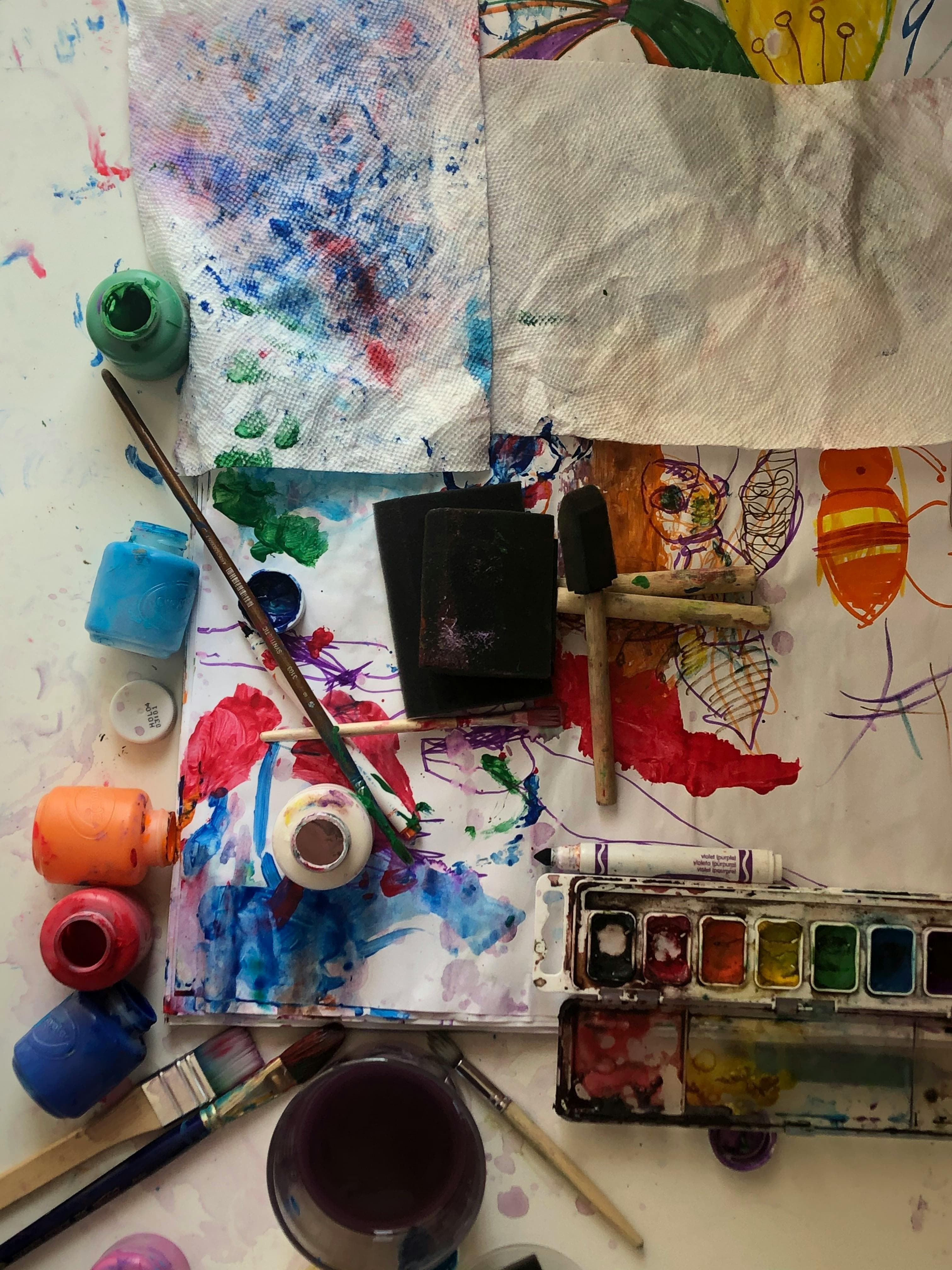 Top-down view of art supplies arranged on a rimmed tray at a process art station