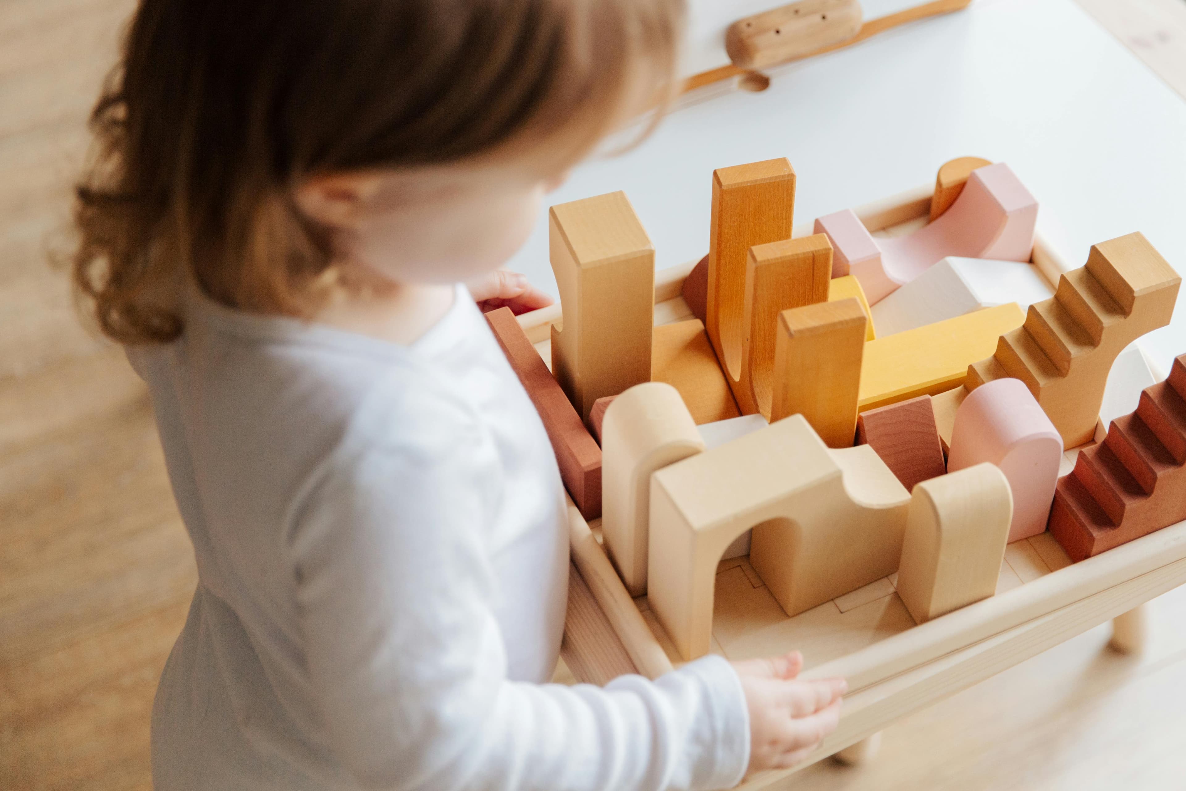 Child pouring sensory base into a paint tray