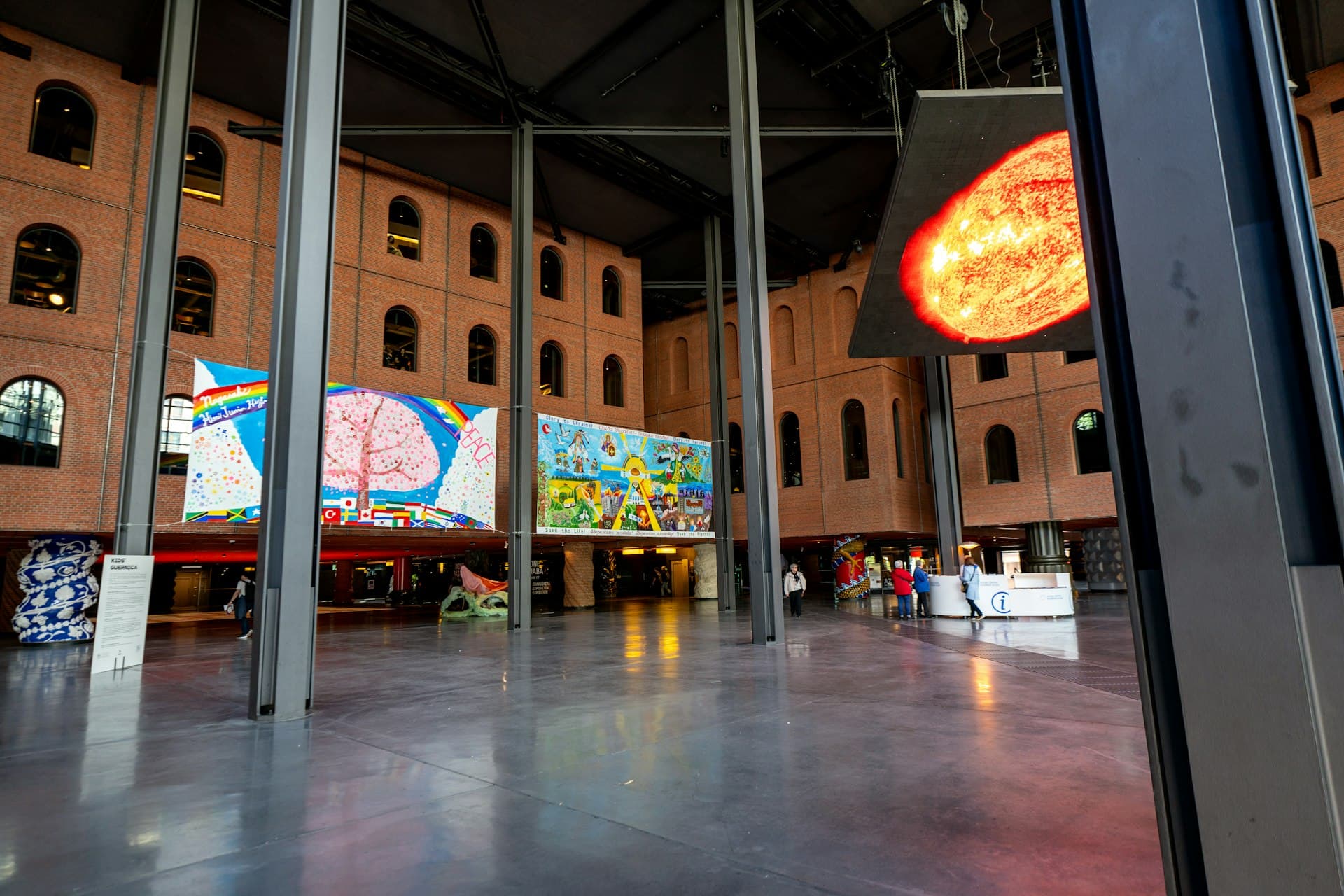 Modern urban courtyard at night with illuminated artwork and architectural details in a cultural venue.